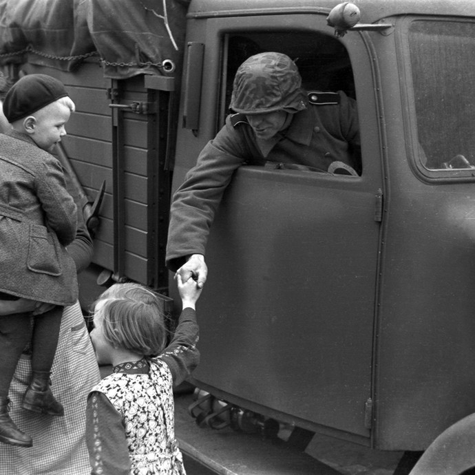 Abzug einer in Raesfeld stationierten österreichischen Einheit der Waffen-SS, Soldat verabschiedet sich von Raesfelder Kindern © LWL-Medienzentrum (vergrößerte Bildansicht wird geöffnet)