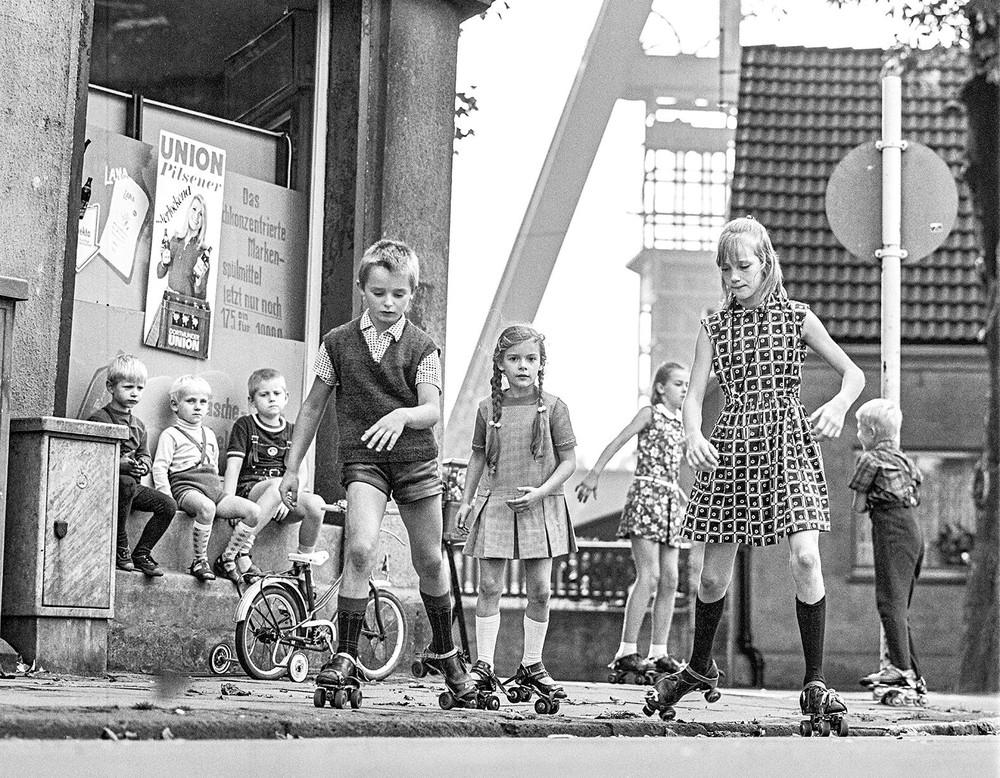 Kinder mit Rollschuhen vor Zechenturm