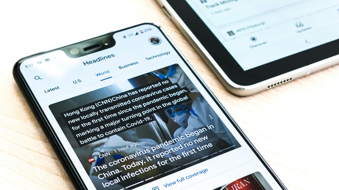 Smartphone mit Schlagzeilen auf einem Tisch