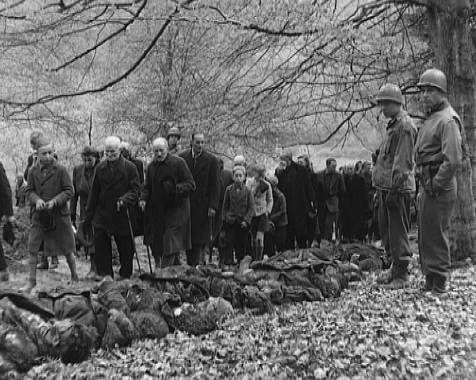 Schwarzweißfoto: Deutsche Zivilisten werden im Arnsberger Wald mit den Opfern von Kriegsverbrechen konfrontiert