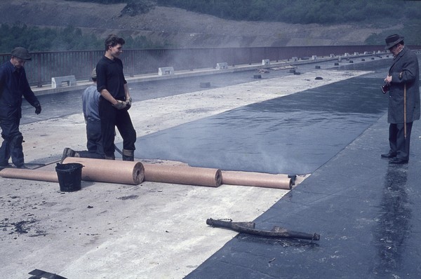 Asphaltbahnen werden zur Abdichtung auf der Dammkrone der Biggetalsperre verlegt. Asphaltbahnen werden zur Abdichtung auf der Dammkrone der Biggetalsperre verlegt.