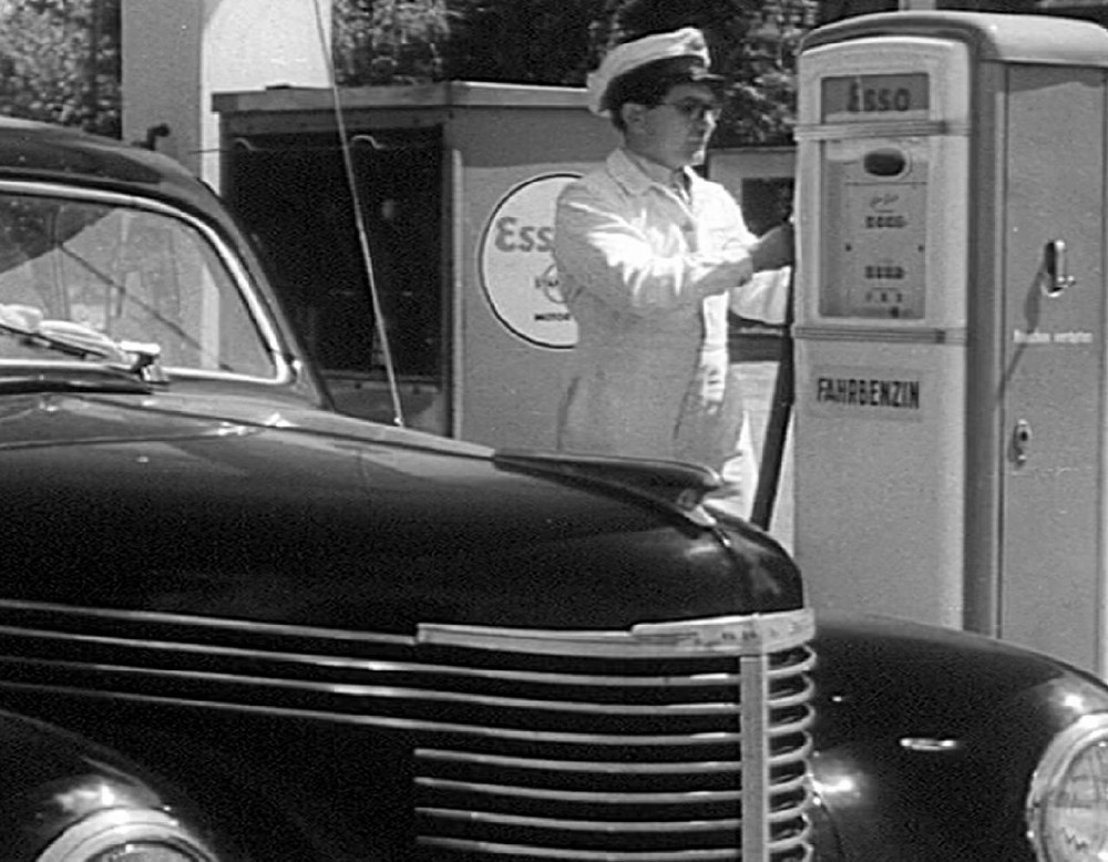 Aufnahme an eine Tankstelle aus den 1950er Jahren mit damaligem Auto