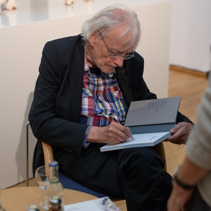 Timm Ulrichs signiert während eines Künstlergesprächs im Kunstmuseum Ahlen Kataloge (vergrößerte Bildansicht wird geöffnet)