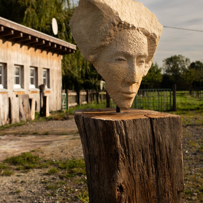 Skulptur eines Frauengesichts aus Baumberger Sandstein von Ulrich Rothmund auf dem Gelände des Steinateliers in Münster (vergrößerte Bildansicht wird geöffnet)