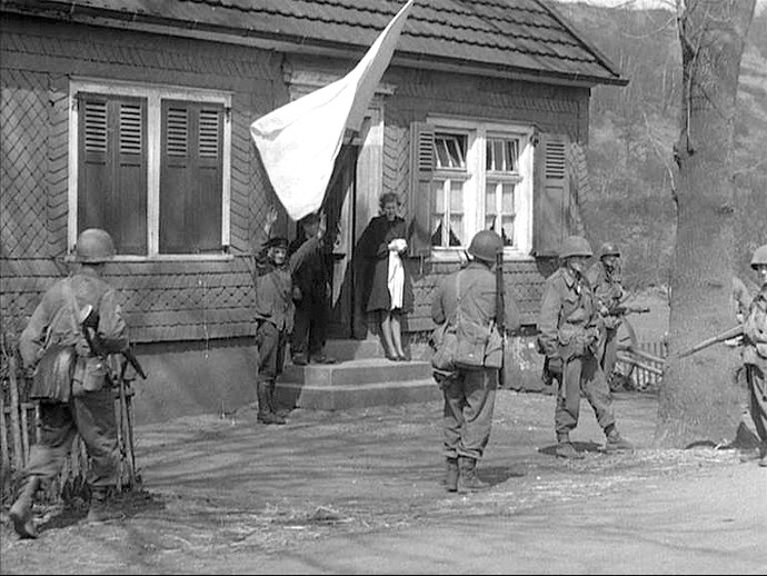 Bewohner eines Hauses bei Olpe empfangen die Amerikaner mit einer weißen Fahne (Film-still/US-National Archives)