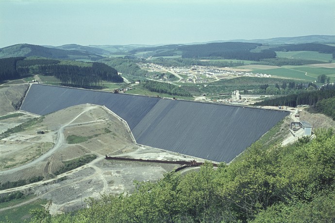 Hauptdamm der Biggetalsperre während der Asphaltabdichtung mit Attendorn Neu Listernohl im Hintergrund. Hauptdamm der Biggetalsperre während der Asphaltabdichtung mit Attendorn Neu Listernohl im Hintergrund.