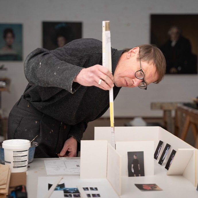 Maler Wolfgang Kessler bei der Planung einer Ausstellung mit einem Modell (vergrößerte Bildansicht wird geöffnet)