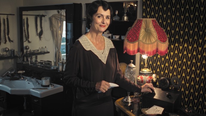 Friseurin Martha dreht das Radio in ihrem Zwanziger-Jahre-Salon an.